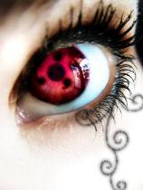 Sharingan-inspired red eye with swirling henna-style eyeliner art