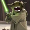 Yoda wields a glowing green lightsaber, ready to duel