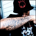 Forearm tattoo close-up under a black cap