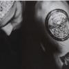 Grainy close-up portrait with a mysterious tattooed eye