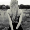 Blonde girl gazing over a quiet field