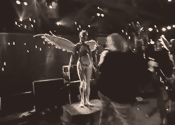 Angel-winged performer on stage, moody sepia shot