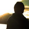 Silhouette watching a golden sunset over the water