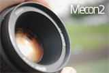 Camera lens close-up branded with 'Mecon2'