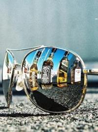 Sunglasses reflecting a lineup of liquor bottles