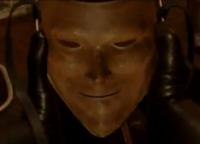 Eerie masked face lit in amber, straight out of a thriller