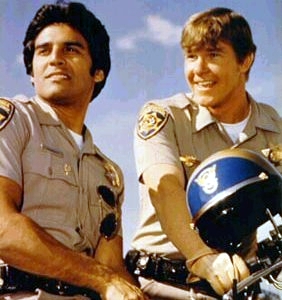 Two CHiPs officers posing on their motorcycles