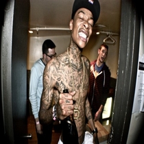 Tattooed guy laughing with friends in doorway