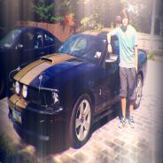 Teen posing with his black Mustang GT