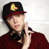 Guy with headphones and backwards cap poses casually
