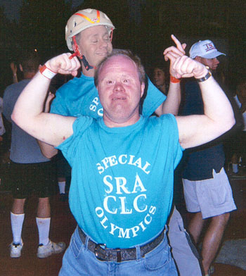 Special Olympics moment—flexing muscles, kid on shoulders